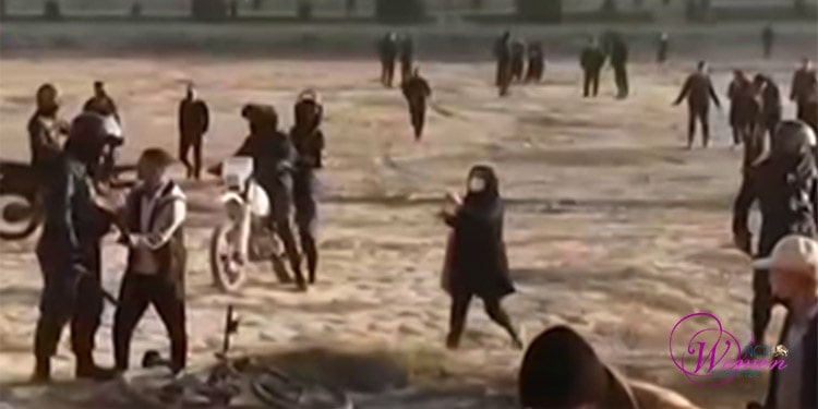 امرأة تندفع مسرعة لمساعدة شخص تعرَّض للضرب على أيدي قوات الأمن، وهم يعتزمون اعتقاله