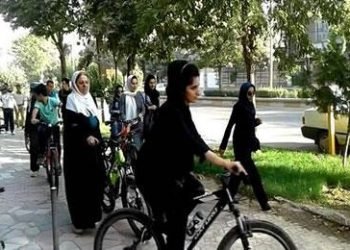 Security forces prevent young women from riding bicycle