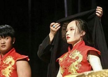 Security agents run on stage to cover Chinese woman’s head